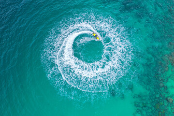 People are playing a jet ski in the sea. Aerial view and top view. Amazing nature background.