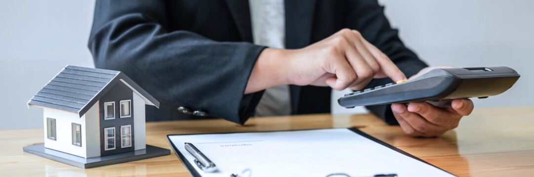 Real estate agent working sign agreement document contract for house insurance approving purchases for client with house model and key on table