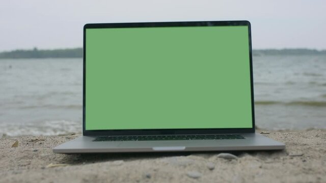 Working from the beach. Remote working new normal. Green screen laptop computer. Footage shot with RED, available in 4K and HD. Download the preview for free.
