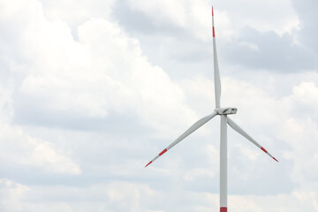 Modern wind turbine against cloudy sky, closeup. Alternative energy source