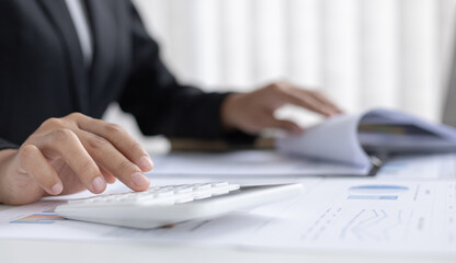 Asian woman is working on finances on her desk.