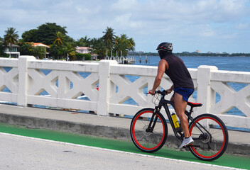 Adult man riding a bicycle on the Venetia Causeway in Miami Beach,Florida.