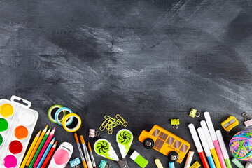 Various school office and painting supplies on black background. Back to school concept. Top view. Copy space