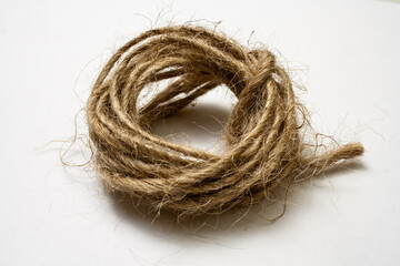 Jute twine isolated on white background. hank of twine close-up. jute rope for packing and decoration. skein of natural jute twine macroshot. Linen rough threads. raw material for industrial