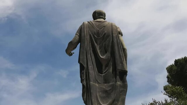 Cloak of the statue of Julius Caesar in Rome with the background of passing clouds