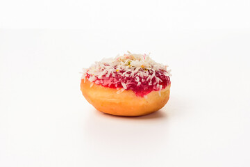 Fototapeta na wymiar A donut coated with strawberry syrup and garnished with coconut and slices of candied fruit