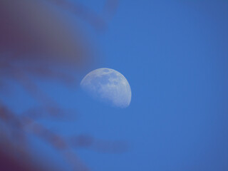 Liguria, Italy - 07/22/2020: Beautiful photography of the moonlight in the different phases with different colours. Black sky and little stars in the background.