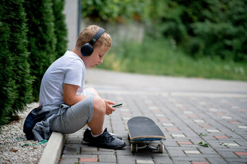 Child playing with mobile phone and listening music in backyard