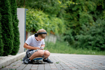 Child playing with mobile phone and listening music in backyard