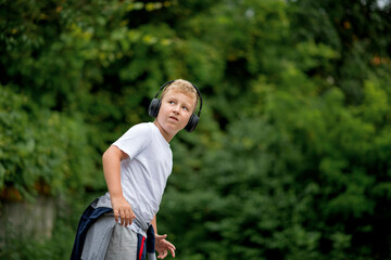 Fototapeta premium Caucasian blond boy listening music from his smart phone