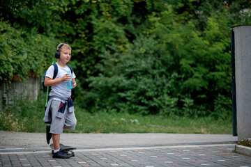 Cool little schoolboy skater boy drinking water. 