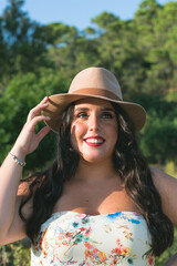 Pretty and brunette girl dressed as a cowgirl in the field