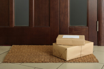 Parcels on rug near door. Delivery service