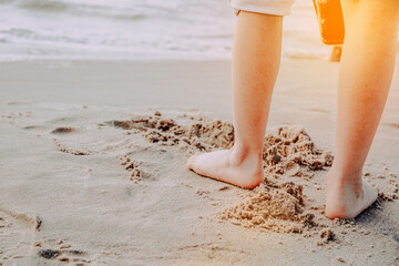 Little boy is playing on the beach by the sea. Vacation and lifestyle concept. A child on vacation spends time at the seaside, playing in the sand.