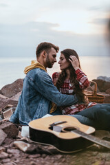 Fototapeta premium selective focus of man hugging girlfriend near acoustic guitar