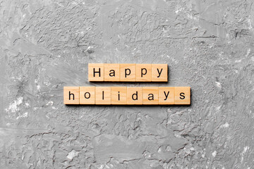 Happy Holidays word written on wood block. Happy Holidays text on cement table for your desing, concept