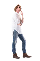 Side view of thoughtful young man with finger on chin looking up planning and watching. Full body length isolated on white background. 