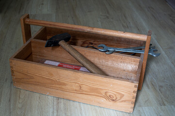 Antique wood tool box with handle and tools on wooden background