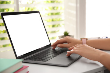 Woman working with modern laptop at white table, closeup