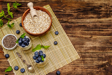 Healthy and useful breakfast concept. Yogurt with blueberries, oat-flakes and chia seeds
