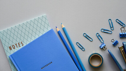 Stationery in blue and its shades on a paper background. Top view. Copy space.