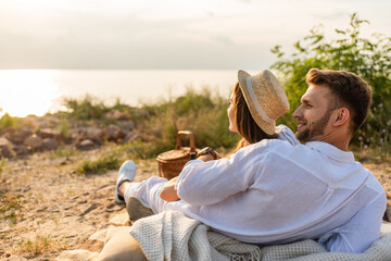 happy bearded man smiling near woman in straw hat