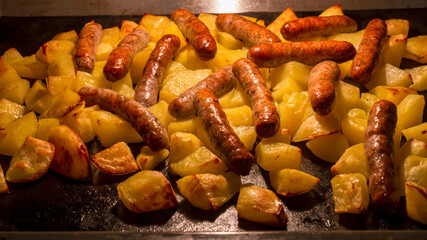 Traditional Nuremberg or Bavarian sausages baked in the oven with potatoes