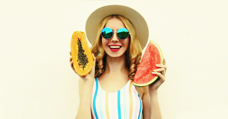 Summer portrait of happy smiling woman with fruits slice of watermelon and papaya wearing straw hat, sunglasses on white background