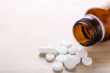 Medicine pills and bottle on wooden table
