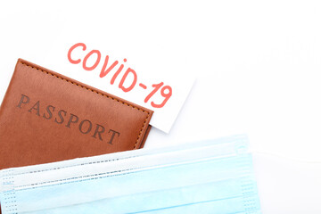 Text Covid-19 with medicine mask and passport on white background