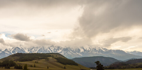 Gray clouds on snow-covered mountains on a rainy day