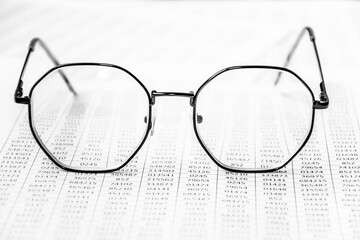 closeup glasses on financial newspaper. Business, finance accounting