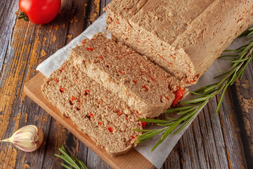 Fresh chicken terrine with vegetables and herbs on a wooden cutting board