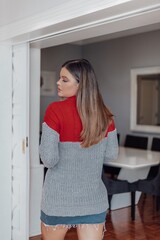 Beautiful model posing for photos in the living room. Wearing denim skirt and gray blouse. 