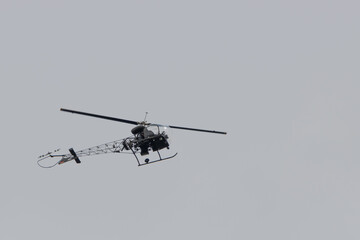 a small helicopter with tubular frame flies in the sky
