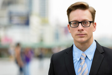 Fototapeta premium Young handsome blond businessman with eyeglasses in the city outdoors