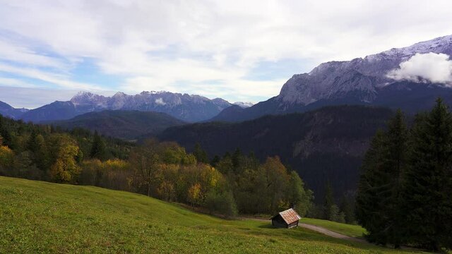 panning shot of an alpine meadow and mountain peaks of the alps from Eckbauer near Garmisch Partenkirchen, Germany