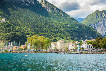 Fototapeta na wymiar Riva del Garda harbor with boats located at the Garda lake.