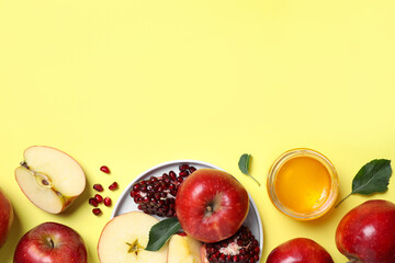 Honey, apples and pomegranate on yellow background, flat lay with space for text. Rosh Hashanah holiday