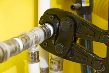 Worker connecting alupex pipes with a tap. Hand press for water pipes PEX - AL - PE-X. plumbing...