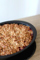 Homemade peach crumble served on a table. Selective focus.