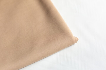 Jersey knitwear, beige fabric. fabric for clothing. fabric on a white background
