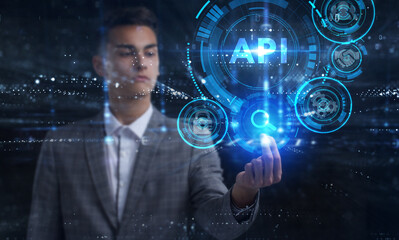 Business, Technology, Internet and network concept. Young businessman working on a virtual screen of the future and sees the inscription: API