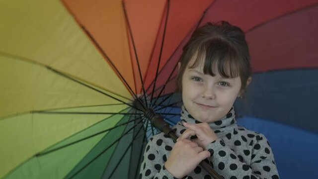 Colorful umbrella mood. Adorable little girl with a multi-colored umbrella.