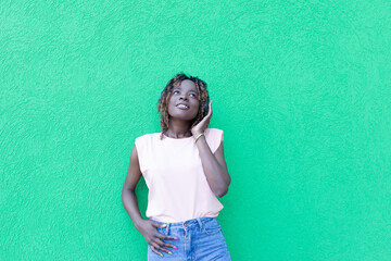 beautiful African American in headphones dancing, against a green background
