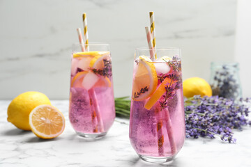 Fresh delicious lemonade with lavender and straws on white marble table