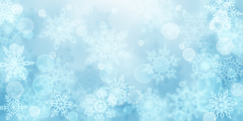 Christmas background of blurry snowflakes in light blue colors