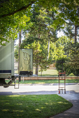 Moving truck with lift gate - older Refrigerator sitting on it and dolly nearby -  in leafy green neighborhood selective focus - obrazy, fototapety, plakaty