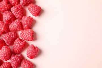 Fresh sweet ripe raspberries on pink background, flat lay. Space for text