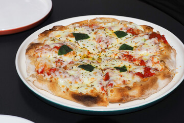Italian food, pizza Margherita with cheese, basil, tomato sauce on plate